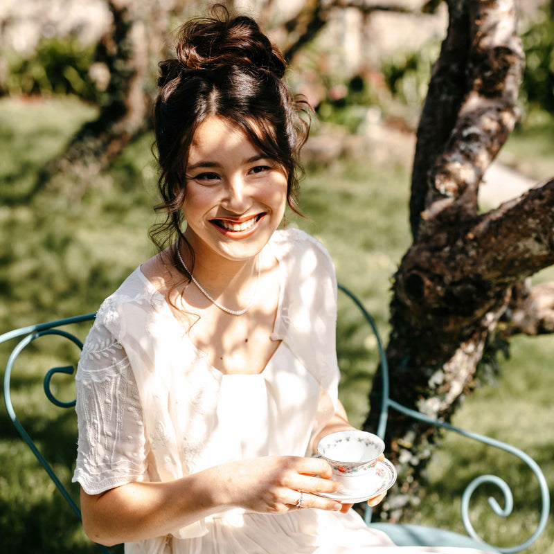 collier en perle d'eau douce porté par une jeune femme dans un jardin